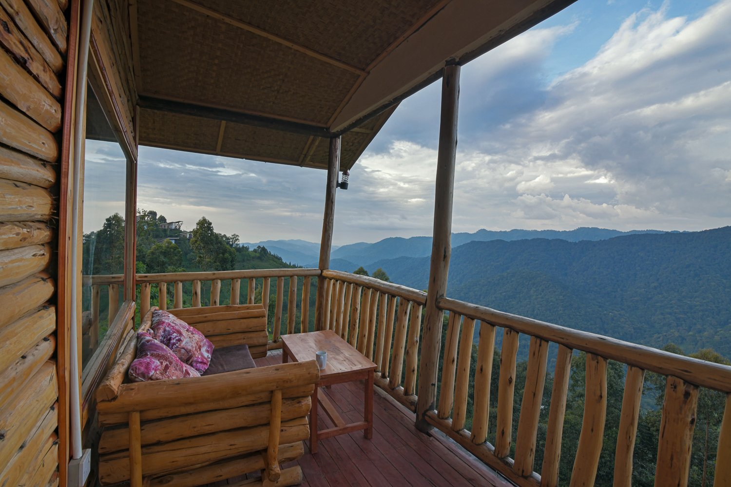 The wooden balcony at Orugano Bwindi Lodge overlooking forested hills